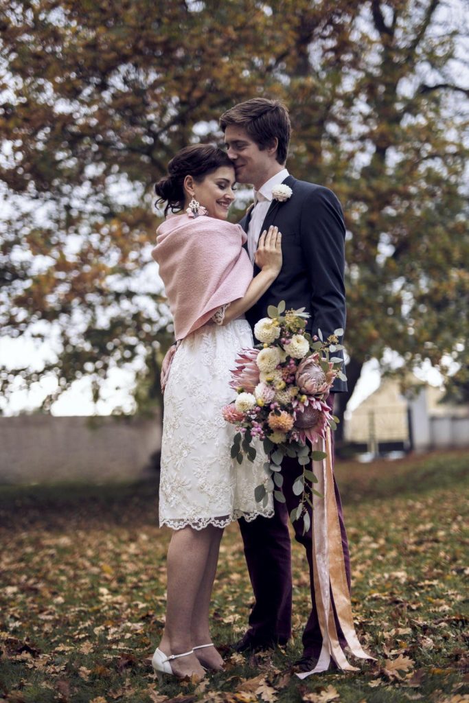 Brautpaar mit Brautstrauß aus Dahlien und Protea sowie Seidenbänder